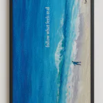 Ocean Spirit decorative infrared heating panel, 60x120cm, featuring a hand-painted seascape with blue waves and sandy shore, framed in black, with the text “follow what feels real”.