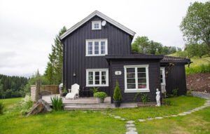 black scandinavian house - old style in a green surrounding